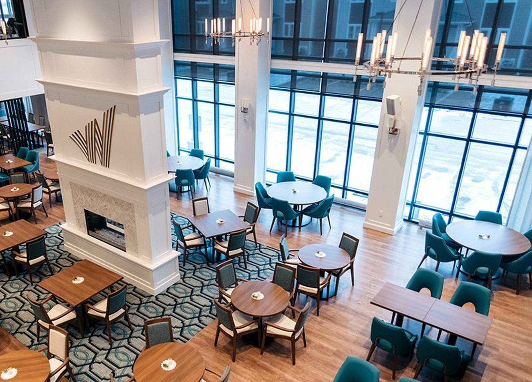 a large dining room with tables and chairs and a fireplace